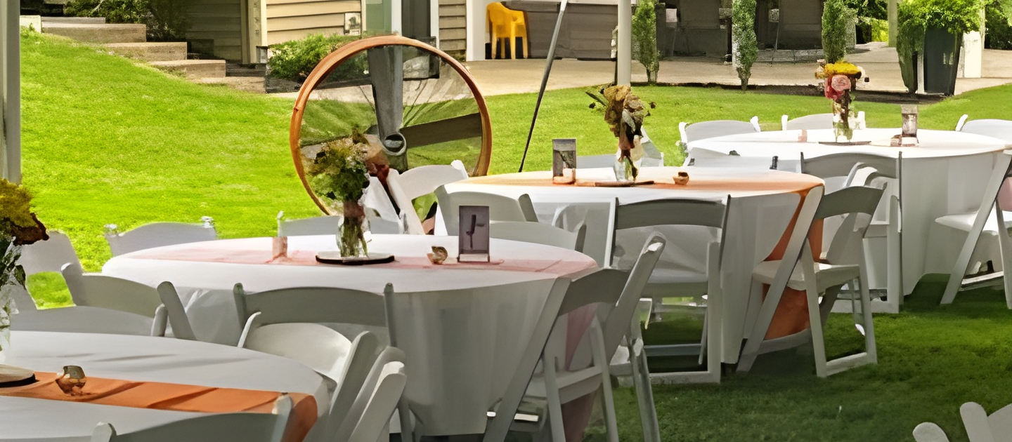 table and chair setup under a highpeak tent rental in Solon